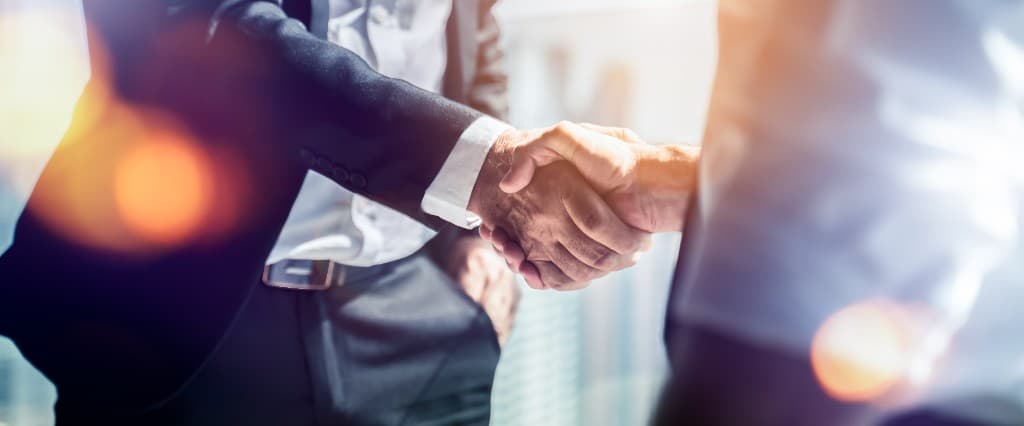 Illustrative photo of two people shaking hands. Not a Legacy Core partner meeting.