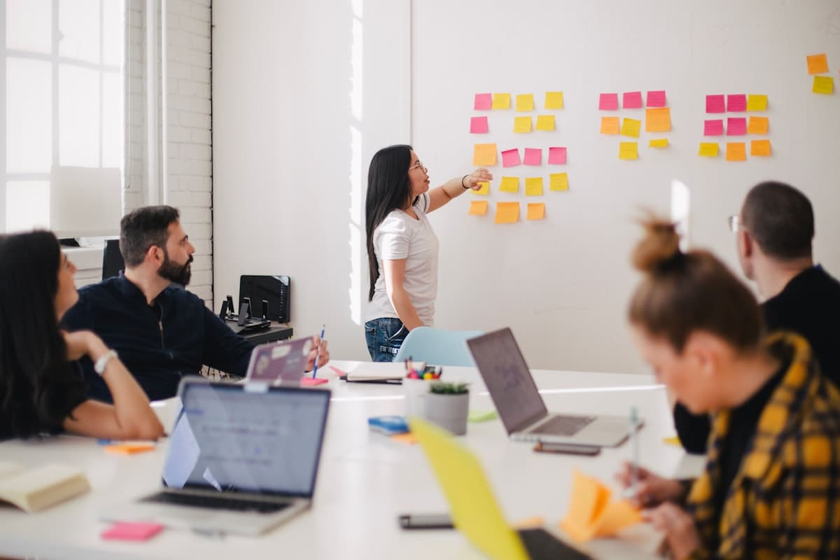 A small team planning a process together with notes on a wall