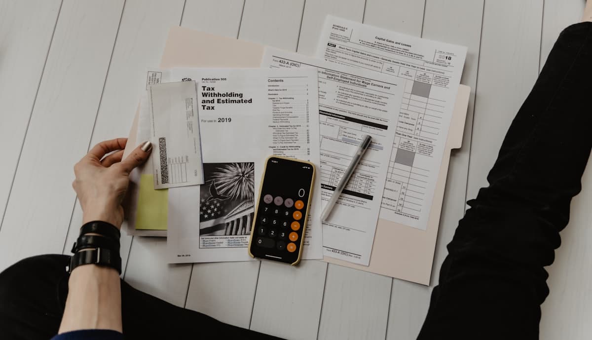 Tax and financial paperwork on a desk being reviewed by an accounting professional