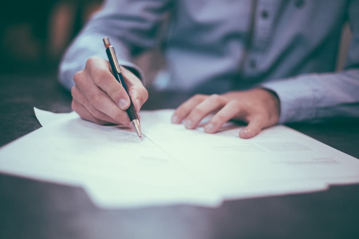 A professional reviewing and signing paperwork at a desk